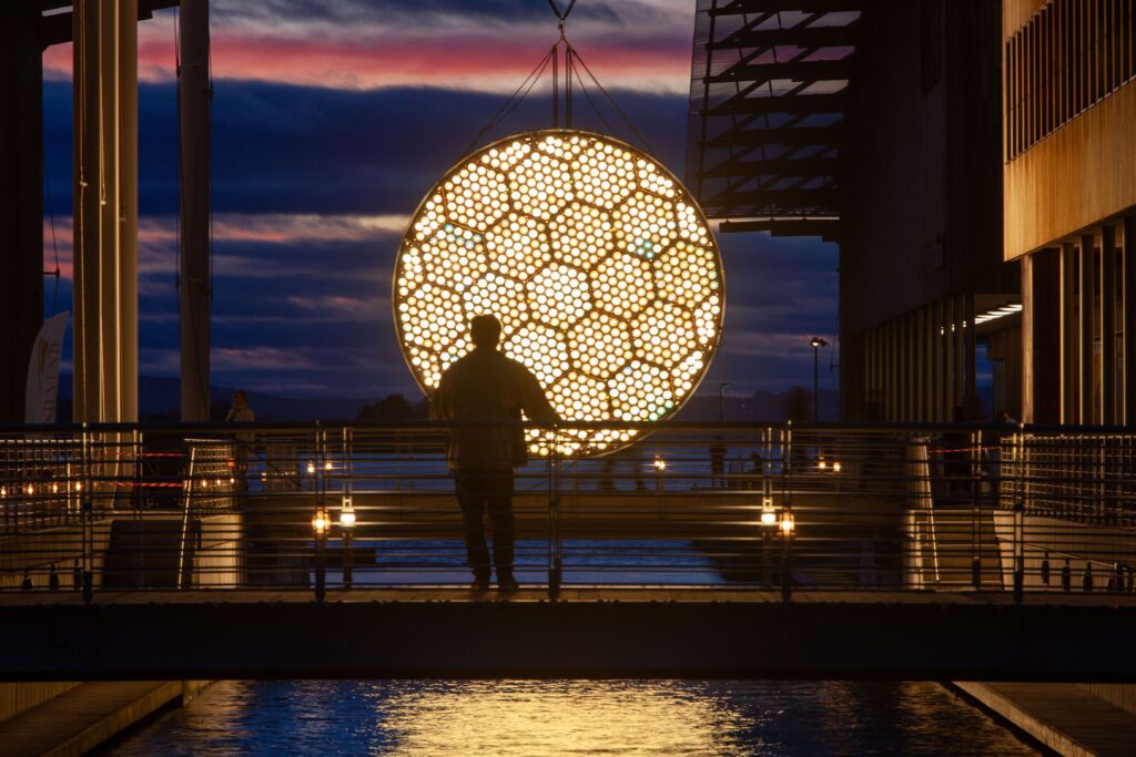 a sun on the horizon in the oslo fjord made with hundreds of light bulbs with a slow animation